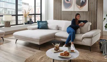 Frau sitzt in entspannter Position auf bequemer Couch